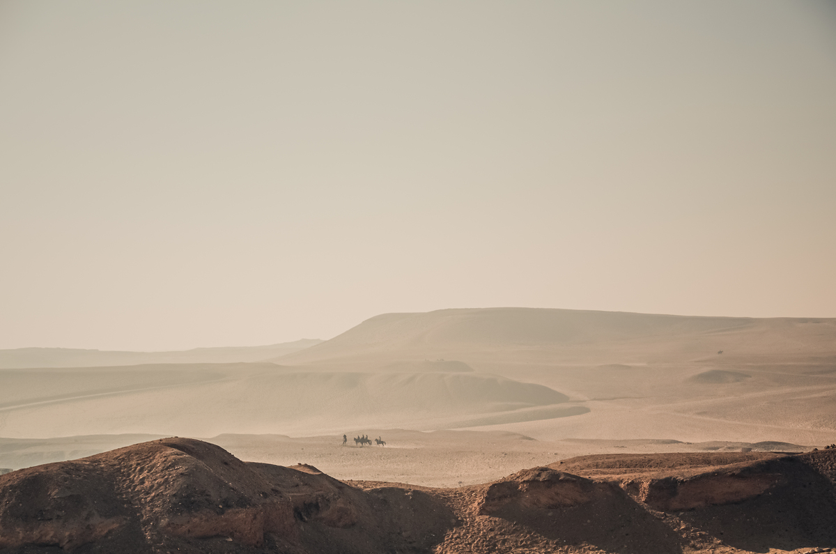Endless yellow sandy hot desert Lonely Egyptians on camels paysage désertique